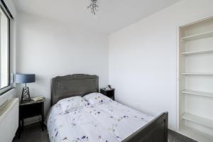 1 dormitorio con cama y pared blanca en RDC FACE A LA MER, en Dunkerque