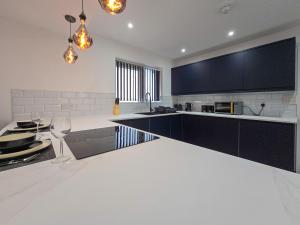een keuken met zwarte kasten en een wit aanrecht bij DYSA Bond Apartments in Blackpool