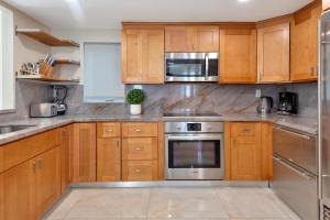 eine Küche mit Holzschränken und Geräten aus Edelstahl in der Unterkunft Luxury Villa 5BR and 3BR in Hollywood Lakes near Beach in Hollywood + 38 Fotos