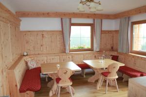 uma sala de jantar com painéis de madeira, mesas e cadeiras em Ferienhaus Innerzarge em Tux