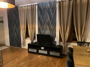 a living room with a tv on top of a table at Villa bodié in Troyes