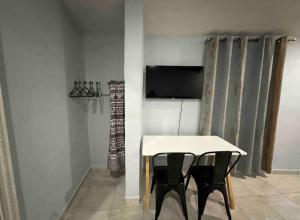 einen Tisch und 2 Stühle in einem Zimmer mit einem TV in der Unterkunft PATO´S in Ciudad Victoria