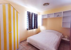 a bedroom with a white bed and a window at Sirenetta in De Haan