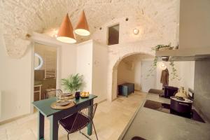 a kitchen and living room with a table and chairs at Palazzo Gentile in Locorotondo