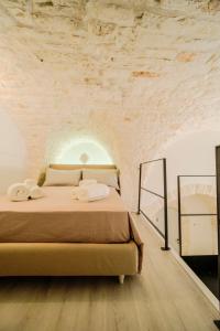 a bedroom with a bed in a stone wall at Palazzo Gentile in Locorotondo