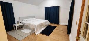 una camera da letto con un grande letto con tende blu di SEA BREEZE of Long Beach NY a Long Beach