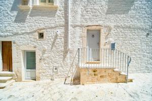 a white stone building with a white door and stairs at Palazzo Gentile in Locorotondo