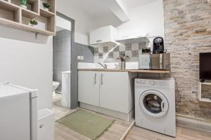 uma cozinha branca com máquina de lavar e secar roupa em 1 - Historic Center - 200m from the Cathedra em Béziers