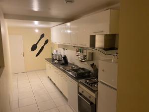 a kitchen with white appliances and white cabinets at Villa bodié in Troyes +15 photos