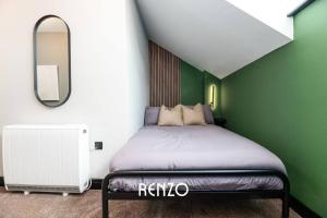 a bedroom with a bed with a green wall at Inviting 2-bed Apartment in Derby by Renzo, Free Parking, Newly Refurbished! in Derby