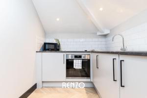 德比的住宿－Inviting 2-bed Apartment in Derby by Renzo, Free Parking, Newly Refurbished!，白色的厨房设有水槽和炉灶。