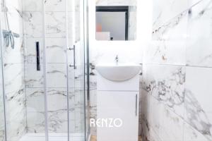 a white bathroom with a sink and a shower at Inviting 2-bed Apartment in Derby by Renzo, Free Parking, Newly Refurbished! in Derby