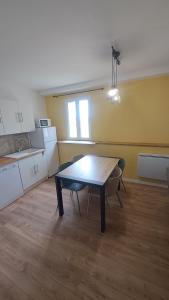 - une cuisine avec une table et des chaises dans la chambre dans l'établissement Jazz et Vacances, à Monlezun