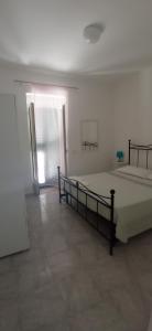 ein weißes Zimmer mit einem Bett und einem Fenster in der Unterkunft Casa Vacanze Villa Francesca in Peschici