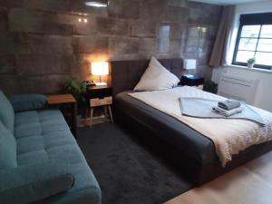 een slaapkamer met een bed en een bank naast een raam bij Nettes Apartment priv. Eingang nähe Weinheim/HD/MA in Birkenau