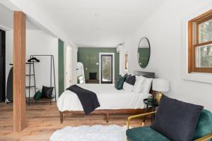 a bedroom with a white bed and a green chair at Hudson Valley and The Berkshires Cottage in Hillsdale