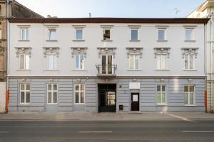a white building with windows and a door at Nawrot Cosy Studio in Łódź