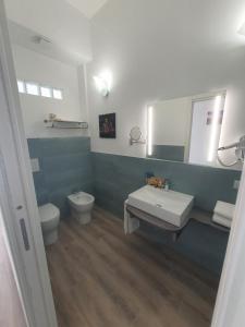 a bathroom with a sink and a toilet and a mirror at The Stunning B&B in Peschici