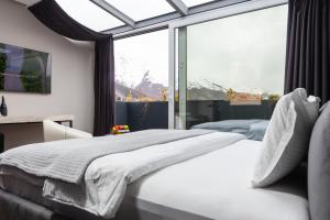 a bedroom with two beds and a large window at Morea Hotel in Prizren