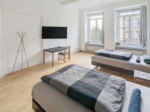 uma sala de estar com 2 camas e uma secretária em Monteur Dreams - Zentrale, Große Altbauwohnungen, 2 Bäder, Küche em Leipzig