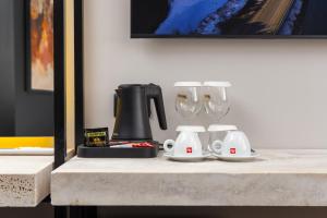 Morea Hotel في بريزرن: طاولة مع آلة صنع القهوة وكأسين من النبيذ