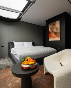 um quarto com uma cama e uma tigela de fruta numa mesa em Morea Hotel em Prizren