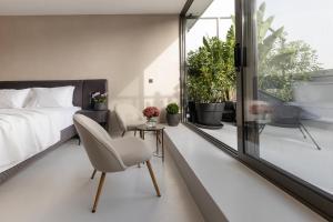 a bedroom with a bed and a chair and a window at Regal Hotel Mitropoleos in Athens