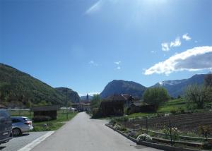 a road in a village with mountains in the background at Gästezimmer Casa Lundo 52 - Casa dell'Estate 52 Lundo in Comano +25 photos