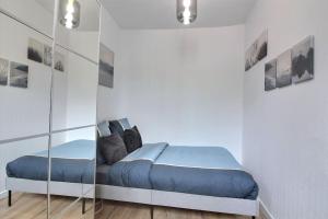 a bedroom with a bed and a glass wall at Le Cocon De Pleyel in Saint-Denis