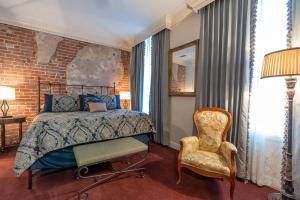 1 dormitorio con 1 cama y 1 silla en Quarter House Suites, en Nueva Orleans