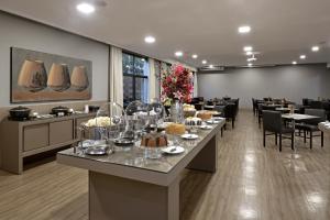 a dining room with tables and chairs with food on them at Garden Hotel in Ribeirão Preto