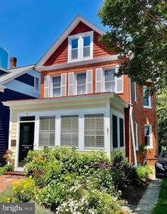 a red brick house with white windows and bushes at Vintage Charm: Annapolis Retreat in Annapolis