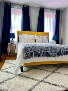 a bedroom with a large bed with blue curtains at Vintage Charm: Annapolis Retreat in Annapolis