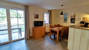 a kitchen and dining room with a table and a television at Argousiers 107 in Fort-Mahon-Plage