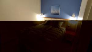 a dark room with a bed with two lights on it at Argousiers 107 in Fort-Mahon-Plage