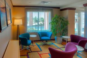 - une salle d'attente avec des chaises, des tables et une fenêtre dans l'établissement Fairfield Inn & Suites by Marriott Mobile Daphne/Eastern Shore, à Spanish Fort