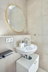 La salle de bains est pourvue d'un lavabo et d'un miroir. dans l'établissement LIVING Apartments / FeWo Neuwied, à Neuwied