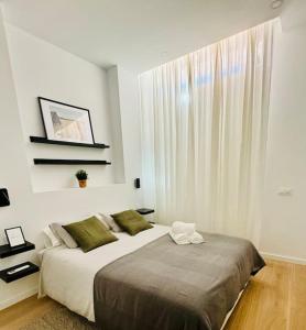 馬德里的住宿－Chic & Stylish Madrid Hideout，一间卧室设有一张大床和一个窗户。