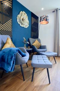 - un salon avec deux chaises et un mur bleu dans l'établissement LIVING Apartments / FeWo Neuwied, à Neuwied