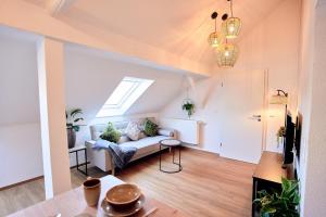 - un salon avec un canapé et une fenêtre dans l'établissement LIVING Apartments / FeWo Neuwied, à Neuwied