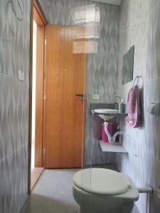 y baño con aseo y lavamanos. en Casa no Guarujá com 1 quarto en Bertioga