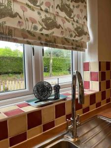 a kitchen with a sink and a window at 3-bed cottage in Sway, New Forest (5 min walk from Sway Train Station) in Sway