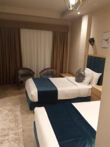 um quarto de hotel com duas camas e uma janela em Coast Hotel em El Alamein
