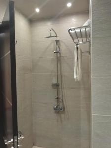 um chuveiro com uma porta de vidro na casa de banho em Coast Hotel em El Alamein