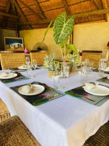 a table with a white table cloth and plates and glasses at Pari Guest House in Middelburg