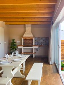 una sala da pranzo con tavoli bianchi e camino di Villas turísticas del noroeste a Villanueva de Arosa