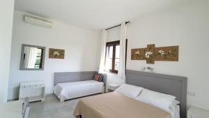 sypialnia z 2 łóżkami i oknem w obiekcie Agrialbergo Capalbio w mieście Capalbio