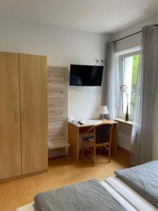 a bedroom with a desk with a computer and a window at Pension Bartz in Traben-Trarbach