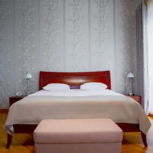 a bedroom with a large bed with a red headboard at Latar Hotel Yerevan in Yerevan