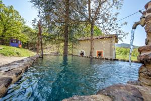 una piscina d'acqua di fronte a una casa di Borgo Tassani a Casaleggio Boiro